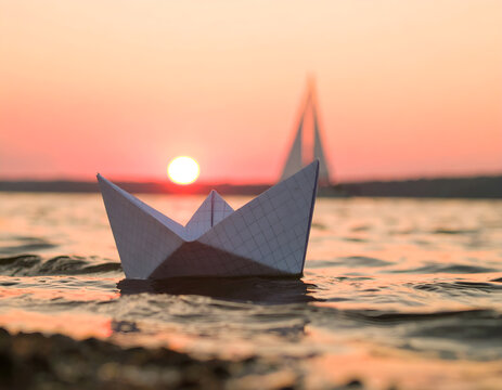Paper boat sailing on the sea at sunset with warm light reflection on water. Generative AI
