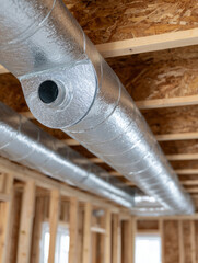 Obraz premium Close-up of metal HVAC ductwork in unfinished building.