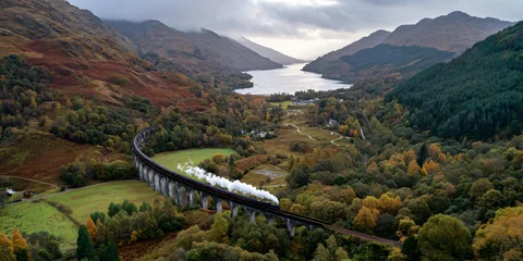 Fototapete Glenfinnan-Viadukt Aerial View of Glenfinnan Viaduct Scotland Scenic Railway Bridge Amidst Rolling Green Hills and Misty Mountains Landscape  © Nikola