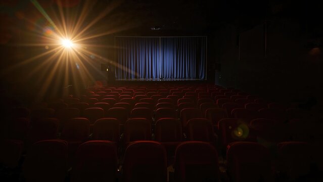 Stage illumination on crimson fabric theater chairs