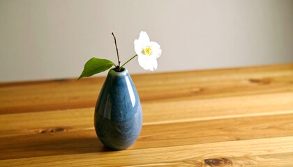 White flower in blue vase on wood
