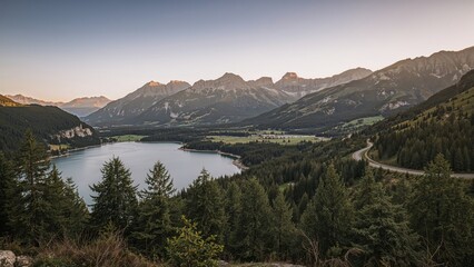Fototapeta premium Tranquil Road Along the Lake Surrounded by Forested Mountains