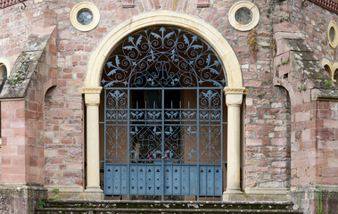 Historic Ornamental Iron Gate with Arched Entry and Stonework Design