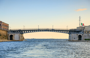 Taranto cityscape with glimpse from sea of the Ponte Girevole (Swing Bridge) in Apulia, southern...