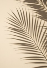 Obraz premium Palm frond shadow cast on a beige wall, sunlight, minimalist aesthetic.
