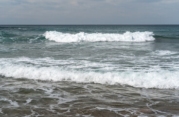 The cold Atlantic Ocean, the white foam of the waves and the golden sand of Zumaia beach