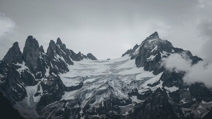 Obraz premium Striking icy glacier nestled between jagged rocky peaks under stormy clouds