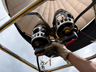 Hot air balloon flight preparation with dual burners and sky background