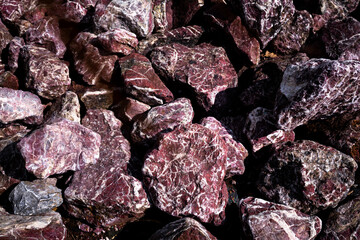Pile of jagged purple rocks with white veins in natural light
