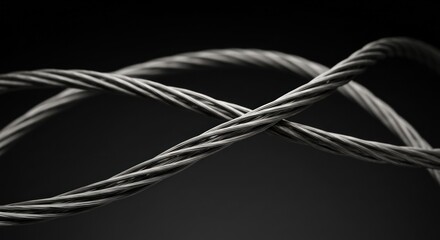 Twisted metal cables with interwoven strands against a dark background