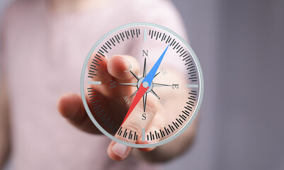 Stock photo of a hand interacting with a digital compass, showing direction and navigation concept.