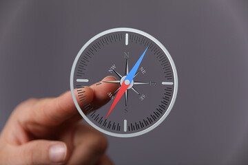 A hand interacts with a digital compass, illustrating navigation and direction finding. Ideal for...