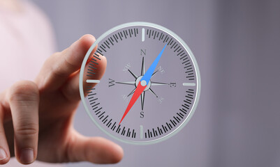Hand holding a digital compass, symbolizing guidance, navigation, and strategic planning.