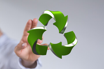 Green 3D recycling symbol in hand. Eco-friendly concept. Sustainable business.