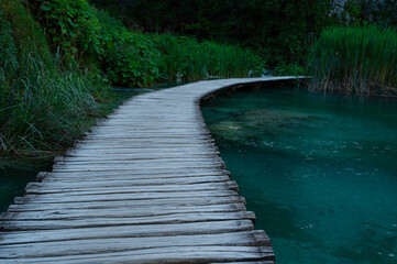 A bridge over Plitvice Lakes waterfall and river with cascades in the national park, valley with...