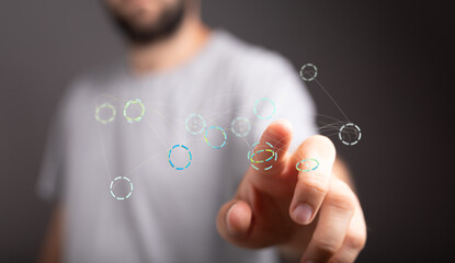 Close-up of a person's hand interacting with a digital network visualization.  Concept for technology, connection, data.