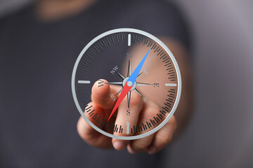 Close-up of a finger interacting with a digital compass interface.  Find your way with technology.