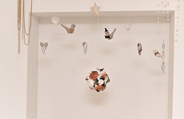Decorative wall with small hanging ornaments, birds, hearts, stars. composition evokes gentle, dreamy mood perfect for events or baby photography, romantic events, weddings and holidays.