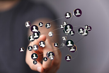 Hand interacts with a digital network of people, representing connections and social media.