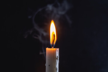 Elegantly lit candle with soft smoke creates a peaceful ambiance perfect for quiet reflection