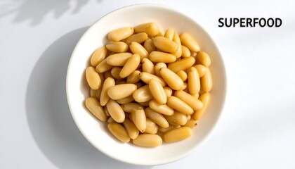 Pine nuts in a white bowl on a light gray surface.