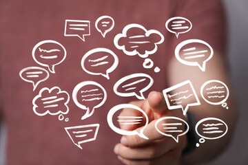 Image depicts a hand interacting with multiple speech bubbles, symbolizing communication,...