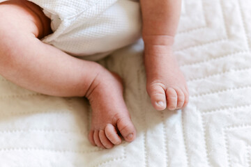 Close-up of newborn baby feet held gently by mother’s hands in cozy home environment