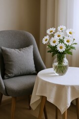 Cozy Interior Scene Featuring a Bouquet of White Daisies on a Round Table Next to a Comfortable Gray Armchair