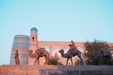 Statue of the People of the Silk Road at Walled Fortress known as Itchan Kala in Khiva, Uzbekistan...