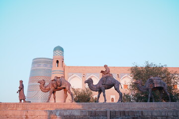 Statue of the People of the Silk Road at Walled Fortress known as Itchan Kala in Khiva, Uzbekistan...