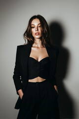 Naklejka premium Fashion portrait of woman in black suit with warm sunlight 