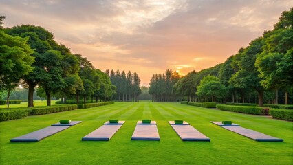 A serene outdoor yoga space with mats arranged on lush green grass under a colorful sky at sunset, surrounded by trees.