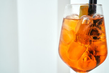 Aperol spritz with ice cubes and orange slice on sunny day