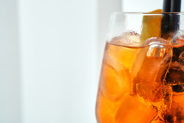Glass of Aperol spritz with straw and citrus wedge