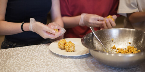 Woman forms chak-chak in kitchen. Traditional Tatar food dessert - fried pastry with honey syrup.