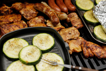 Summer BBQ feast! Grilled chicken, sausages, and zucchini.