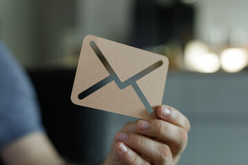Image of a person holding a paper email icon. Perfect for contact us pages, newsletters, and...