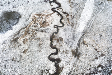 A top down aerial view of a winding river in a snowy landscape abstract nature concept