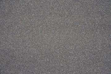 Seamless uniform dark gray stone granules texture, gravel aggregate surface background