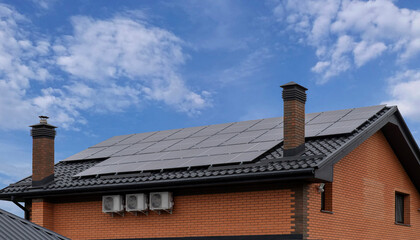 Brick house with metal roof and solar panels under blue sky