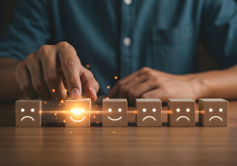 A customer's hand selects a glowing wooden block with a happy face icon, representing a positive review and excellent customer experience. The concept of choosing the best rating for a satisfaction su