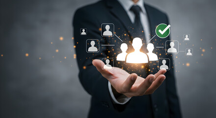Businessman holding a holographic display with people icons, symbolizing human resources, recruitment, and customer relationship management. A futuristic concept of team building, leadership, and sele