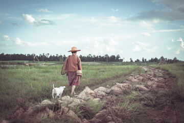 Woman in Traditional Clothing Walking with Dog in Agricultural Field Under Cloudy Sky in Rural...