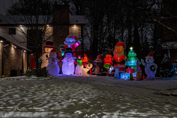 Illuminated houses, Christmas trees and inflatables in night, Burlington, Ontario, Canada.
