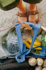 Close up of hand with a vegetables and greens in shopping basket on the local Farmers market....