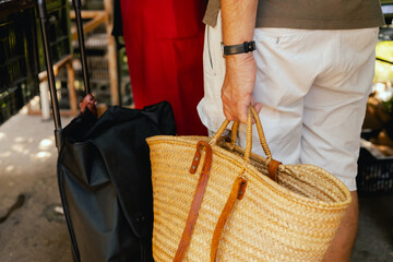 Close up of buyer with shopping baskets for vegetables on the local Farmers market. Close up