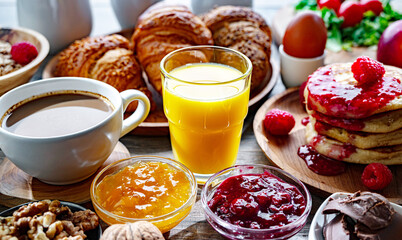 Breakfast served with coffee, orange juice, pancakes, croissant