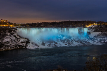 Niagara Falls by night with projected beautiful colours illuminating the waterfall, Ontario, Canada