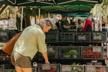 Middle-aged woman blogger filming on the farm market. Mature Female Customer Shopping At Farmers...