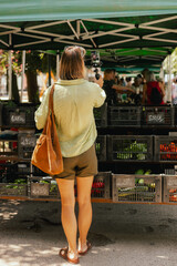 Middle-aged woman blogger filming on the farm market. Mature Female Customer Shopping At Farmers...
